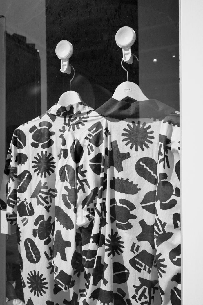 Services Monochrome patterned shirts on hangers indoors, artistic fashion display.